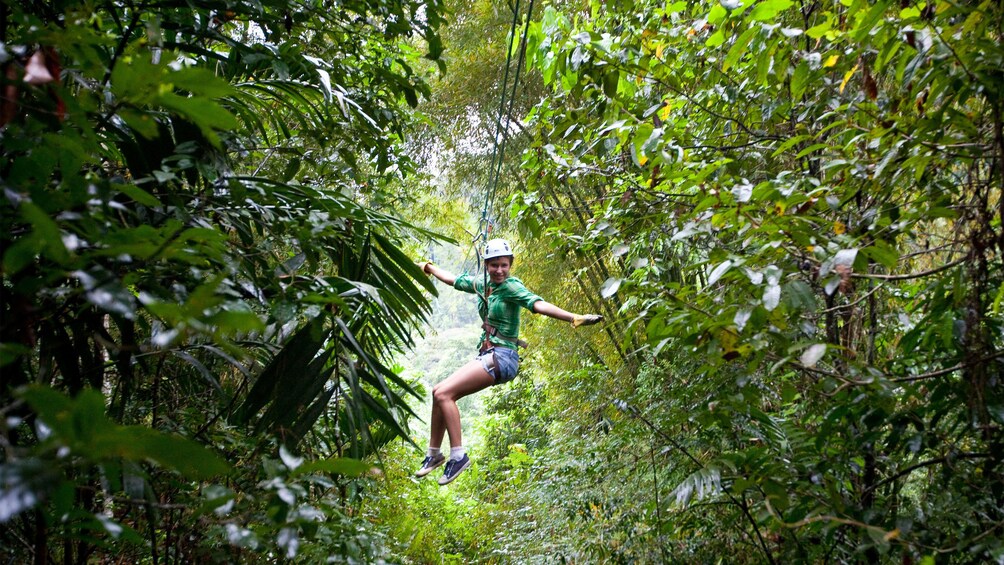 ziplining woman extending arms out for balance in Saint Lucia