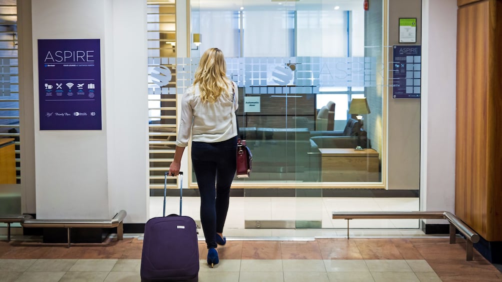 woman entering the Aspire airport Lounge