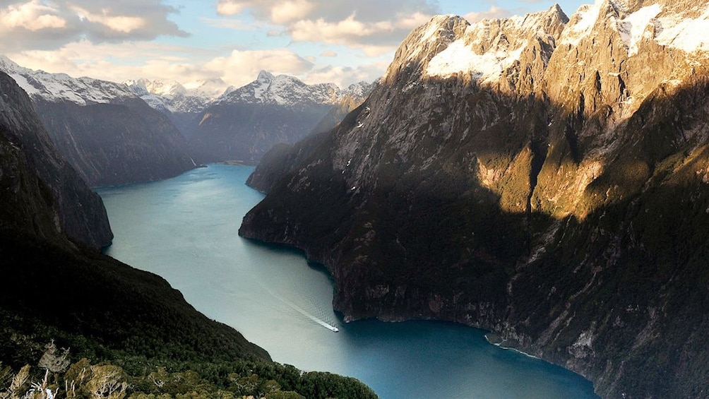Show item 3 of 8. A river cutting through snow capped mountains
