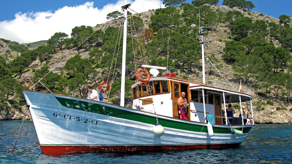 Sailboat anchored and man fishes in Pollensa Bay