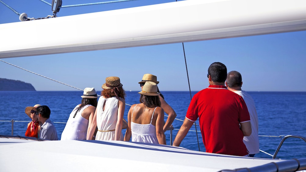 People look out to sea on deck of Catamaran