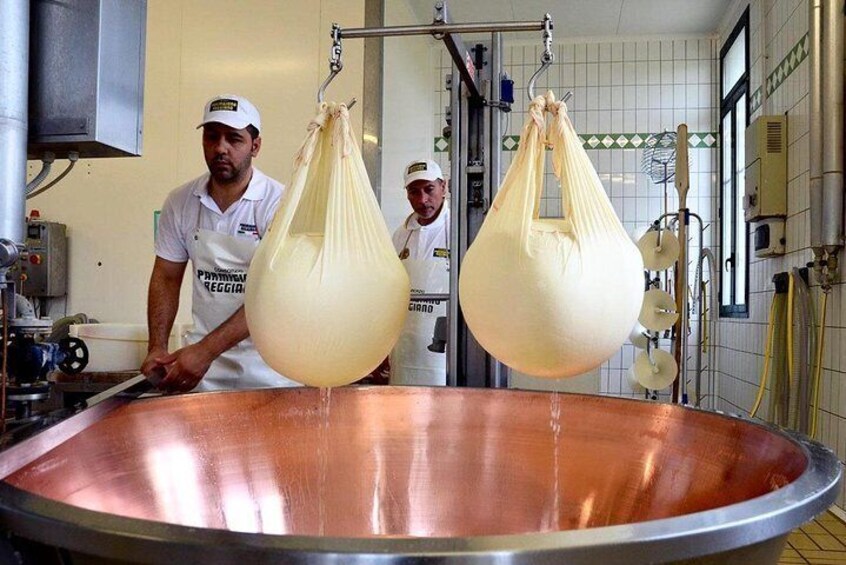 Parmigiano Reggiano Master Cheesemakers lifting the cheese out of the cauldron | Artemilia Guided Tours | Half Day Private Emilia Foodie Experience
