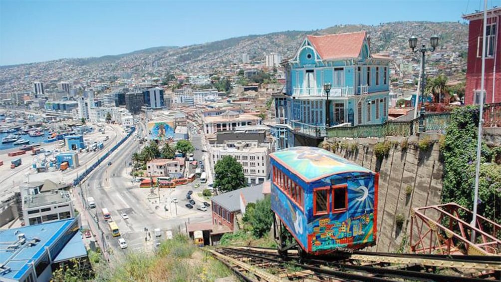 Aerial view of city with small trolly going down tracks.