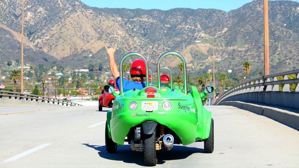 Show item 1 of 3. Scooter drivers on a street in Los Angeles