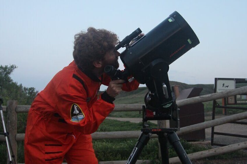 An AstroTours.ors astronomer carefully aims the telescope for viewing