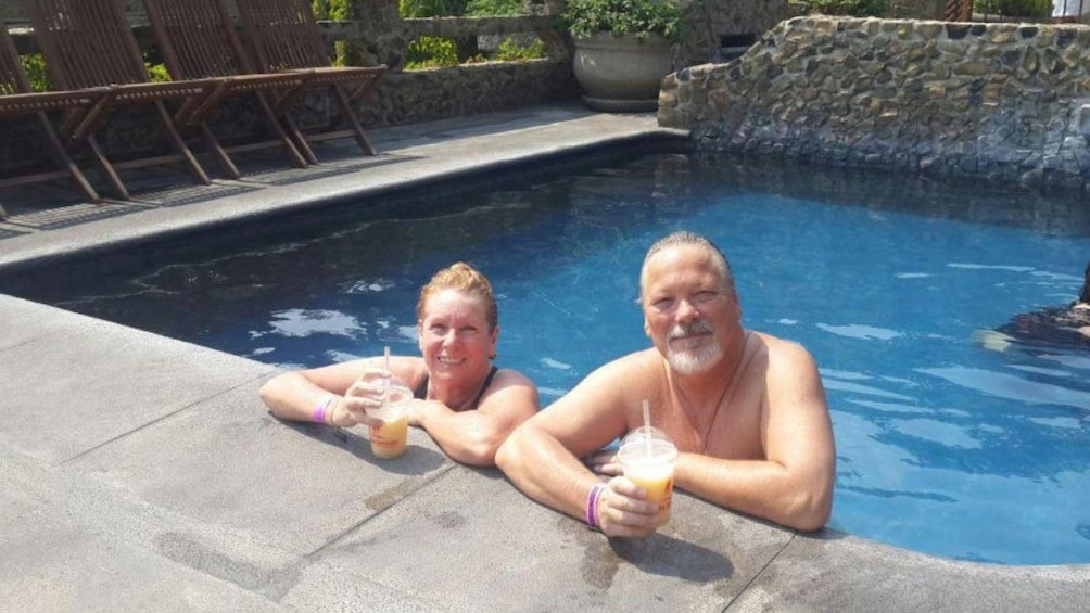 Couple enjoying cocktails while bathing in the hot springs