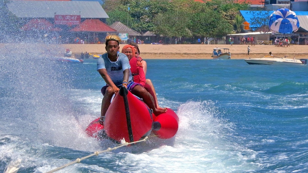 Show item 4 of 5. group on inflatable raft pulled by speedboat in Bali