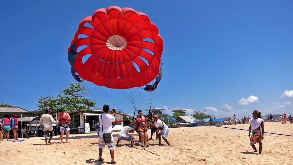 Show item 5 of 5. woman setting up to go parasailing in Bali
