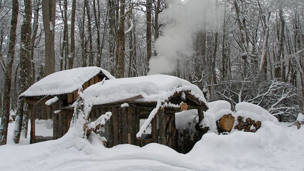 Log cabin and snow at the   White Adventure tour in Ushuaia