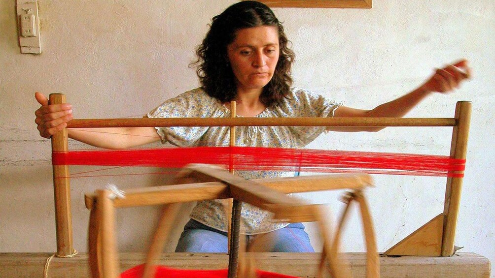 Woman weaving threat with a loom in Cuenca