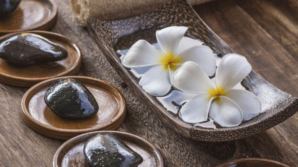 Close up of massage stones and flowers.