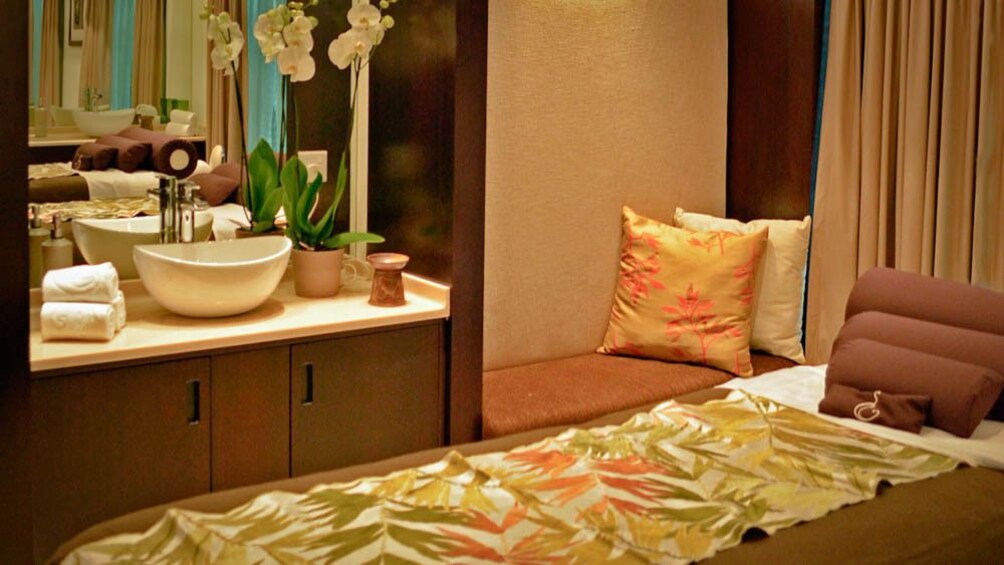 View of luxury massage room, with bed, and sink.