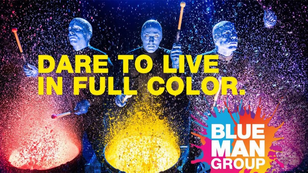 Blue Man Group banging on paint covered drums in New York
