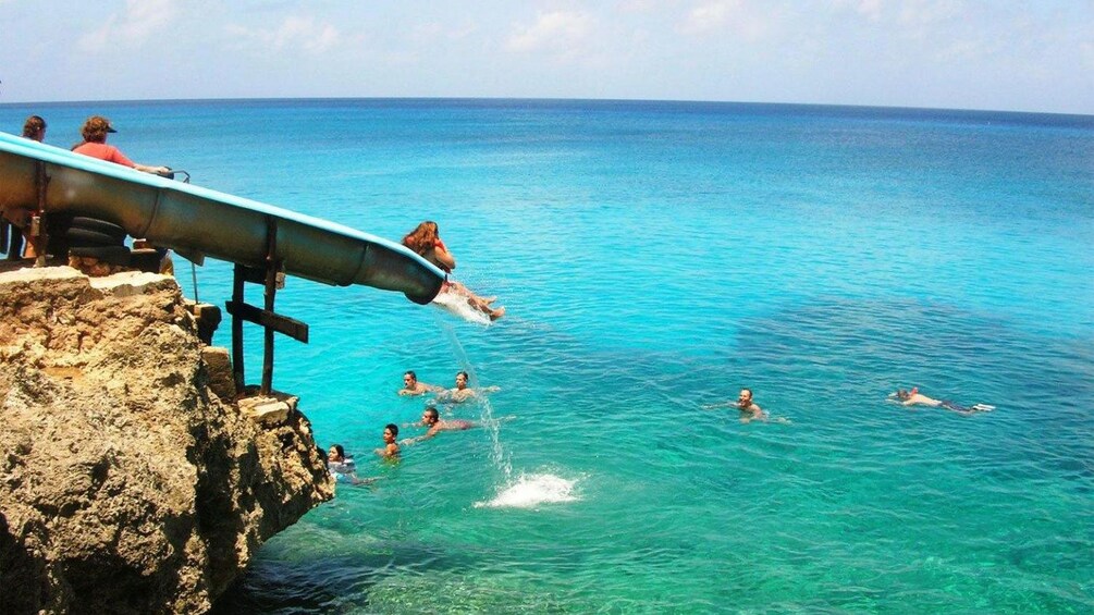 riding a slide down a low beach cliff in San Andres