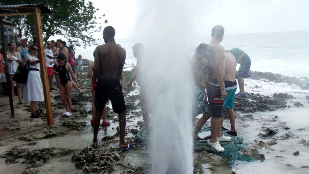 group crowding around a geyser in San Andres