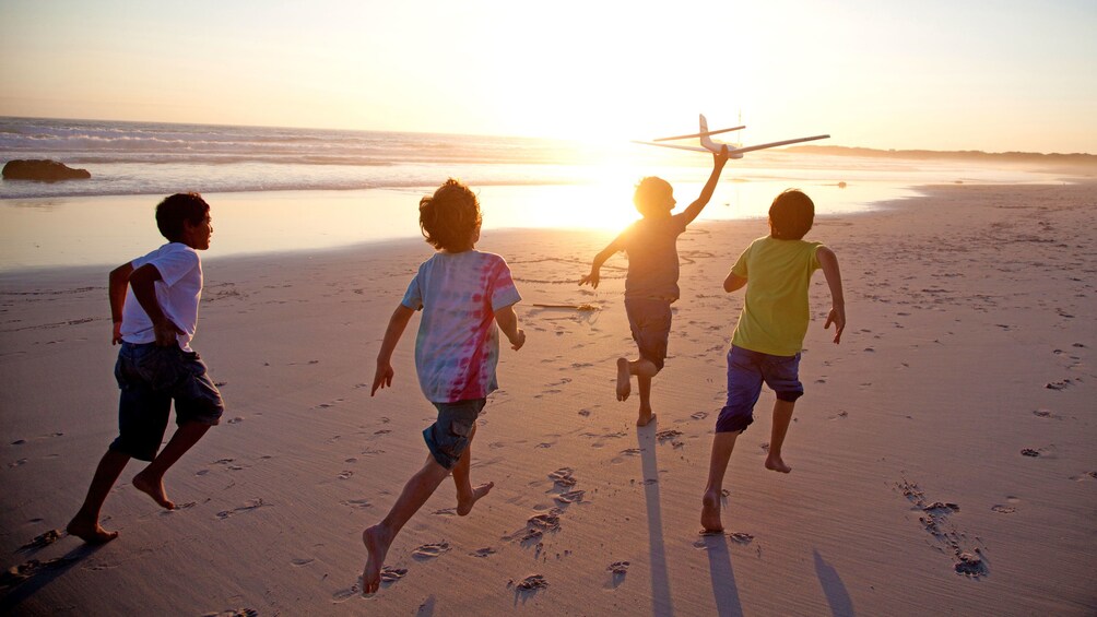 children running along the beach at sunset in Bali