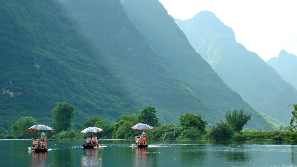 passengers riding on small paddled rafts in Guilin