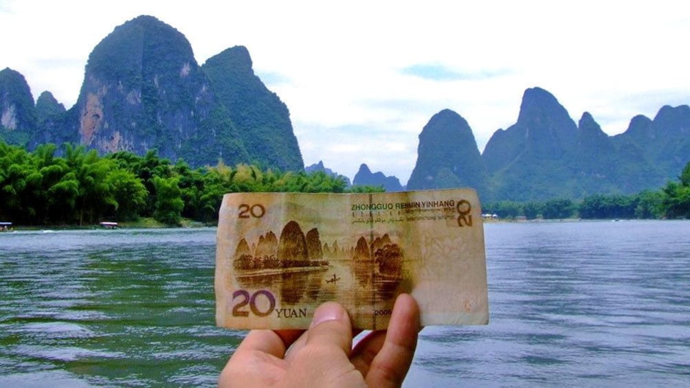 visitor holding up Chinese currency at Guilin