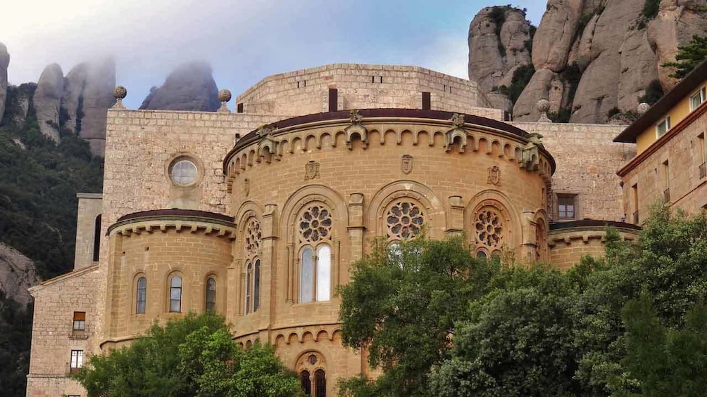 ornate building among trees and rock formations 