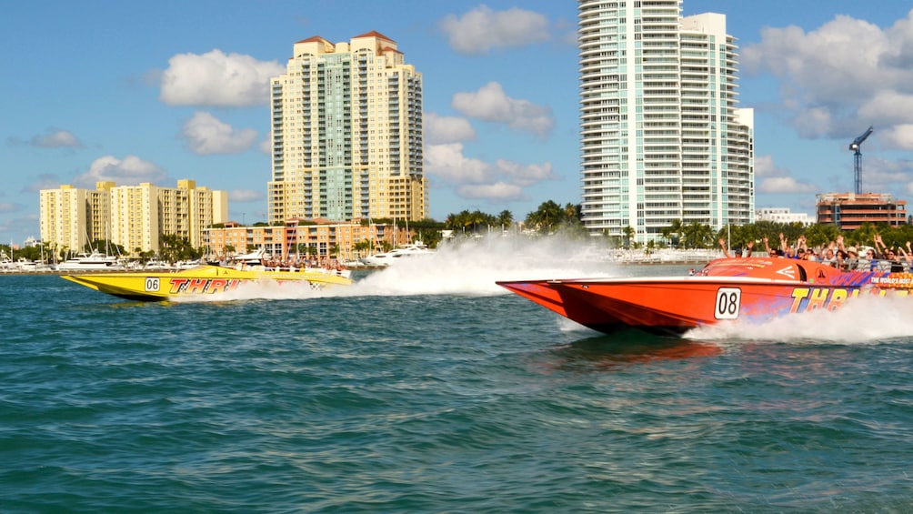 A red and yellow speedboat power thorough the water off of Miami 