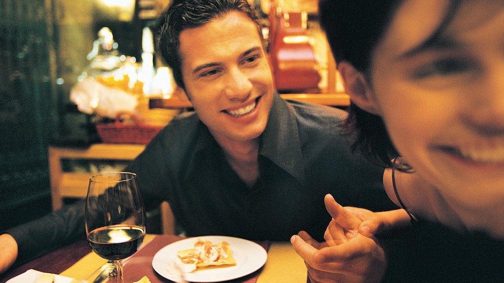 Show item 4 of 5. Couple enjoying wine and food at a restaurant in Cleveland