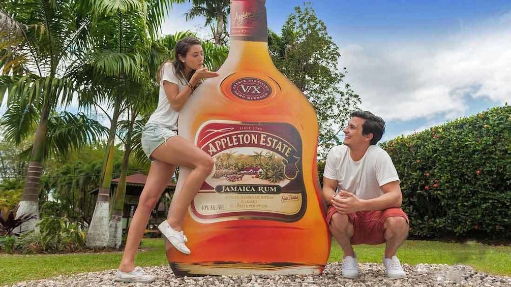 friends posing with giant rum bottle in jamaica