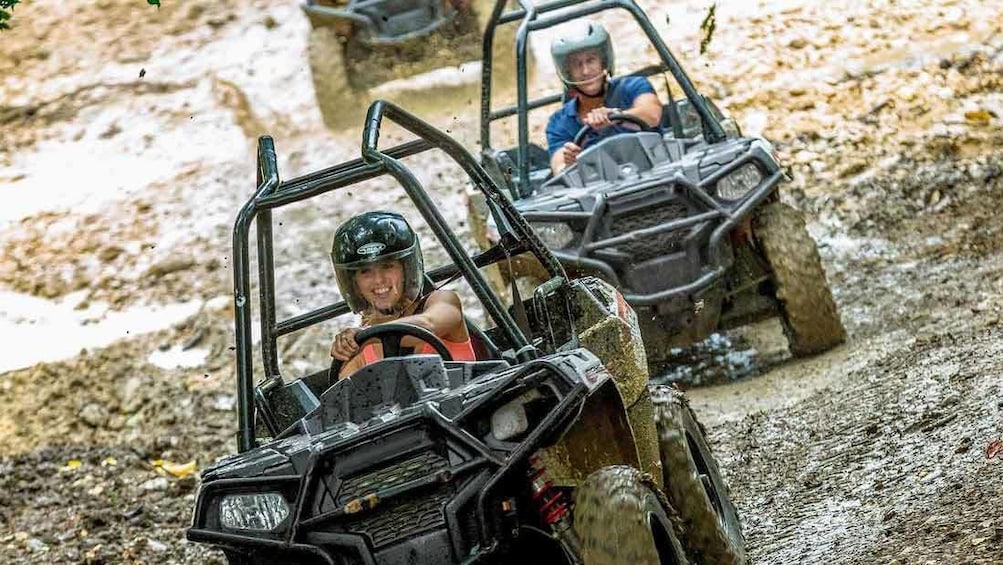 People riding ATV through muddy area in Jamaica 