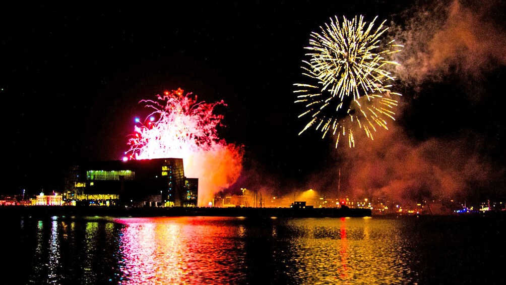 Fireworks exploding in a harbor