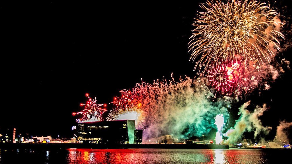 Fireworks exploding in a harbor