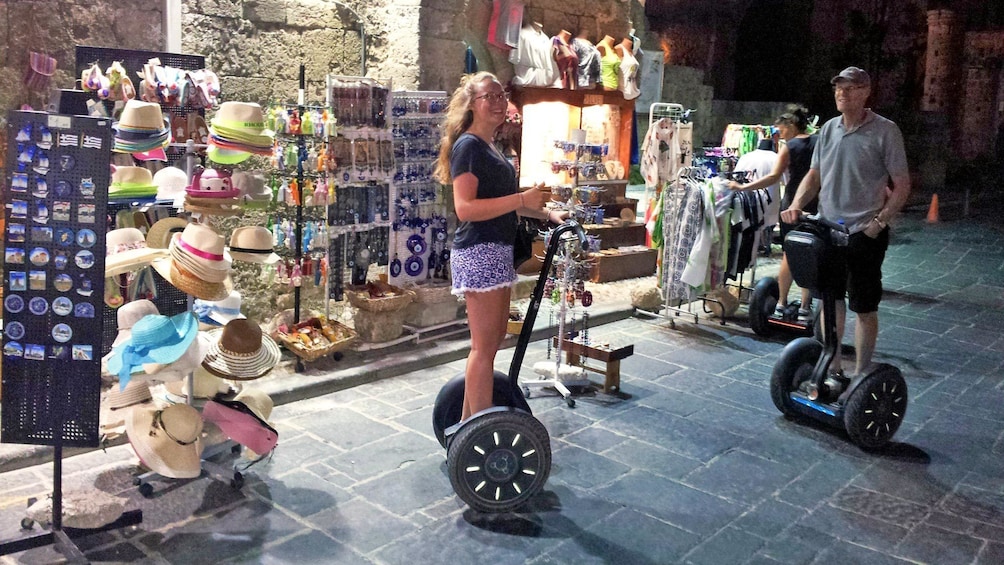 Foto 3 von 5 laden Father and daughter on segways in front of shops in Rhodes, Greece