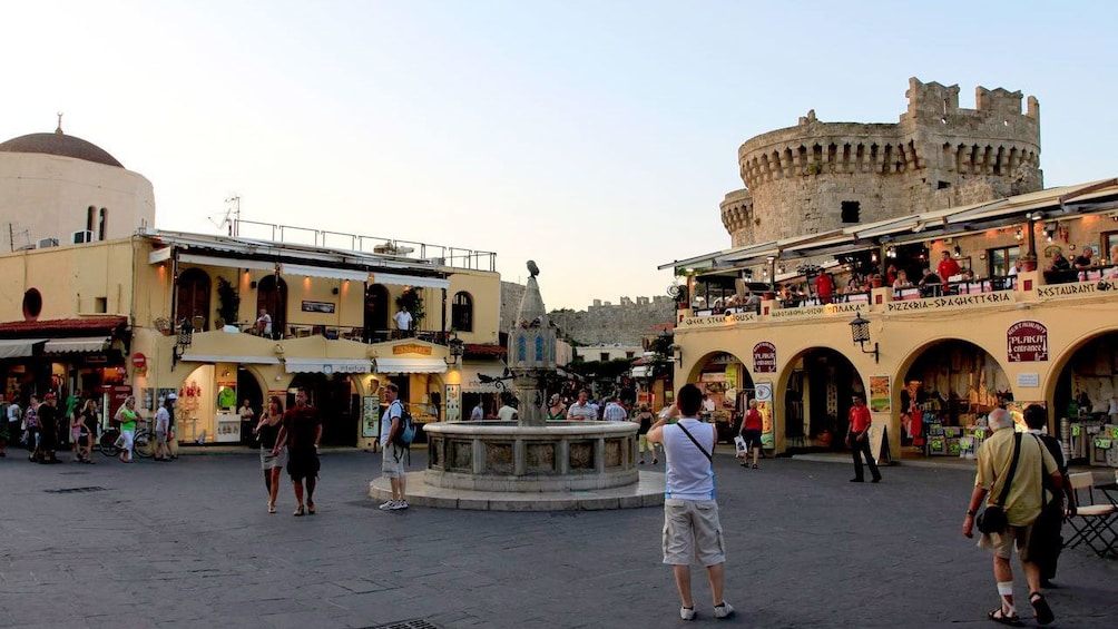 Tourist takes picture in Grecian town square.