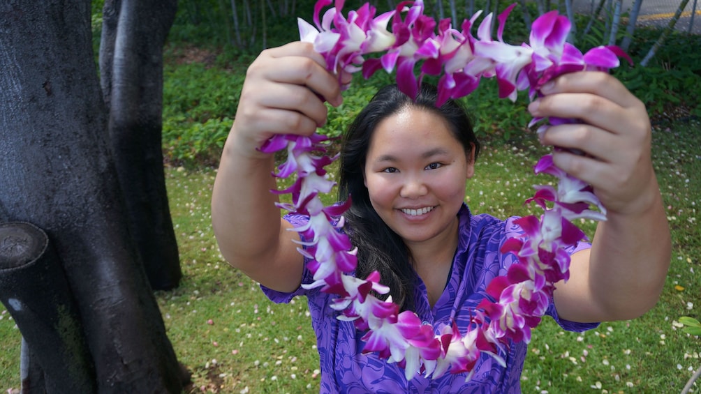 Smiling woman ready to place lei around a customer