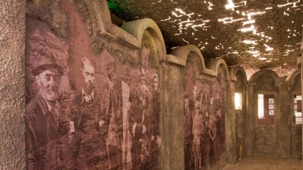 Hallway of old museum shown with artwork on walls.