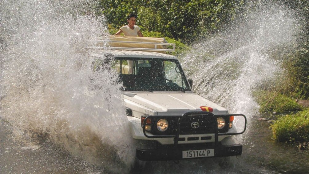 Show item 4 of 4. White Jeep driving through water.