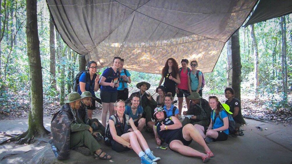 Tour group under shaded tent area.