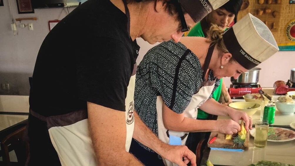 Group members in pitching preparing food in cooking class.