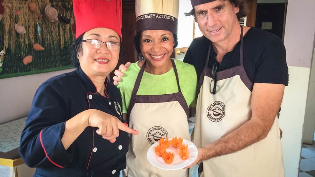 Group members and cooking teacher posing with completed dish.