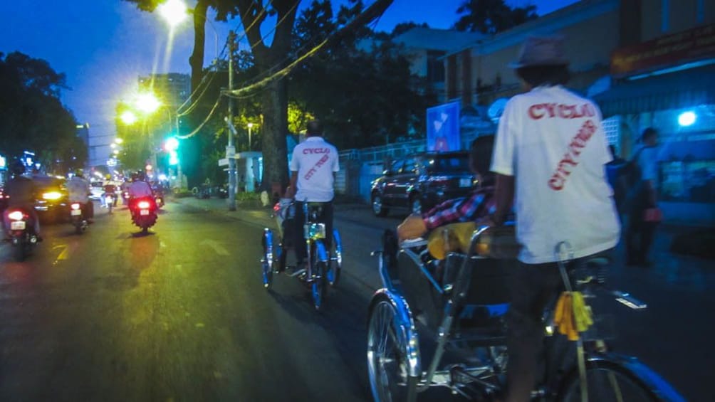 Cyclists on the streets of Saigon at night.