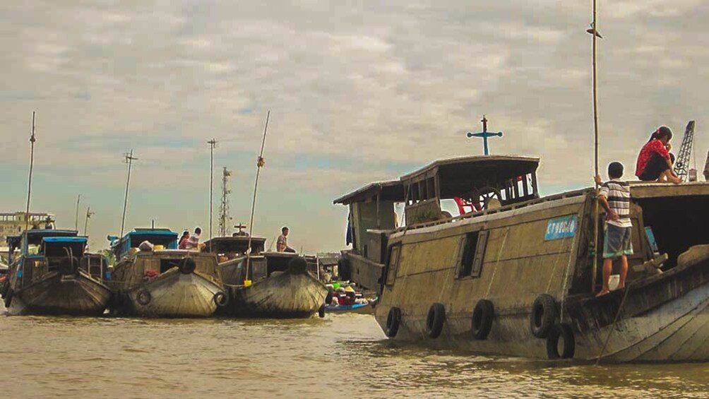 View of fishing boats in river during cloudy day.