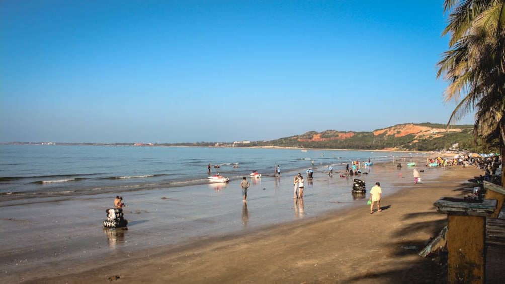 Landscape view of people on the beach during the day.