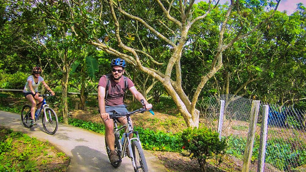 Male and female couple riding on bike path in Mekong Delta.