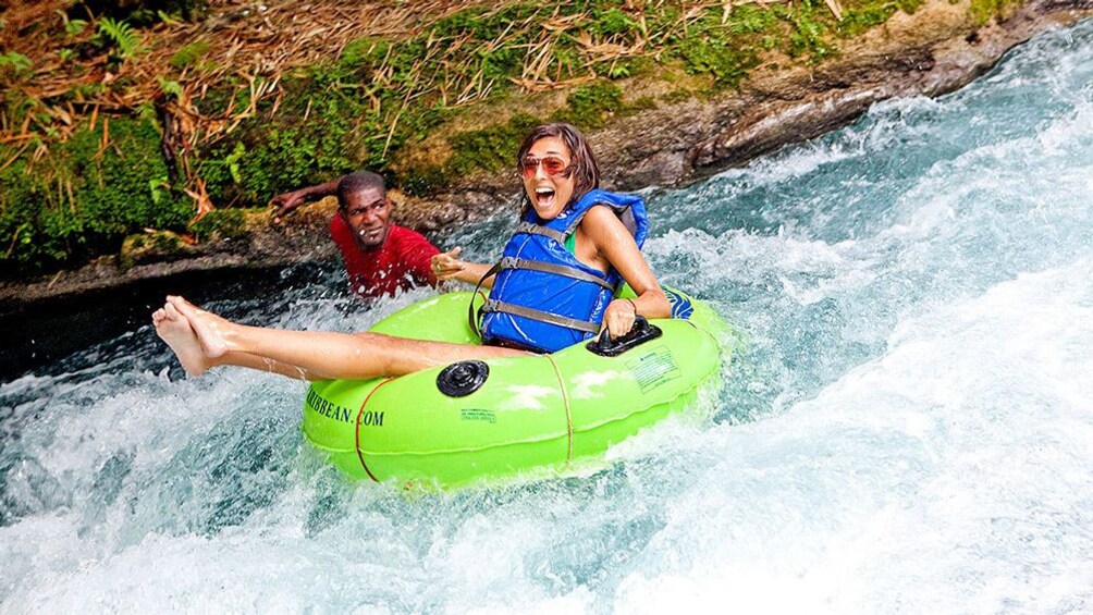 Woman moving down river on floats.