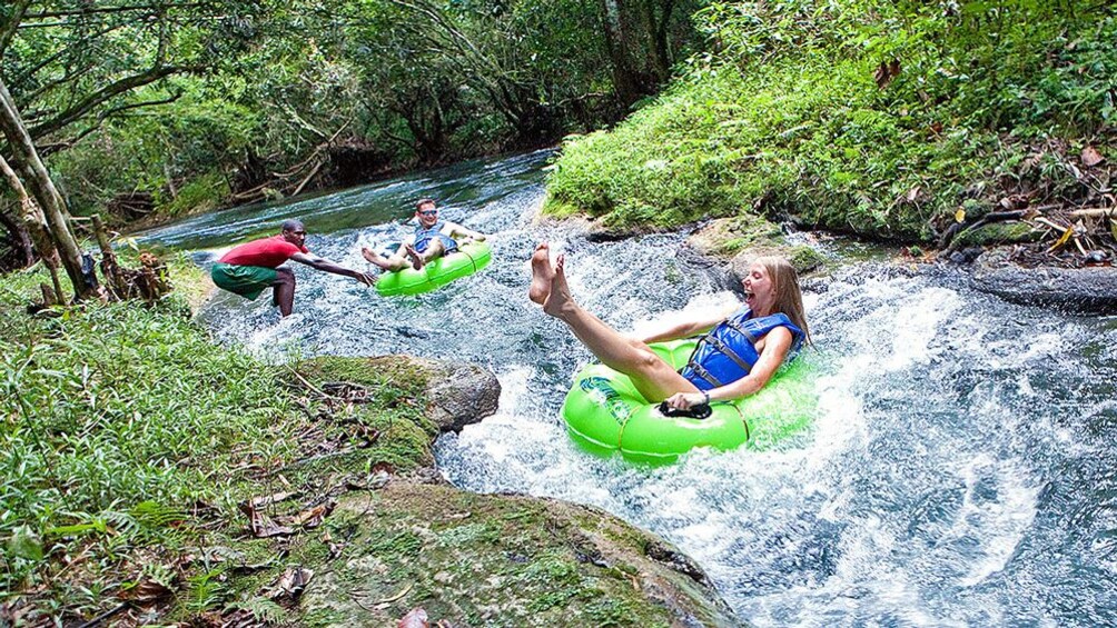 Two people moving down river on floats.