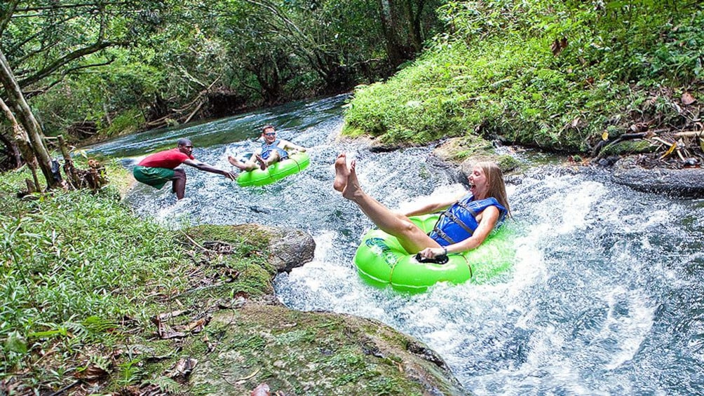 Two people moving down river on floats.