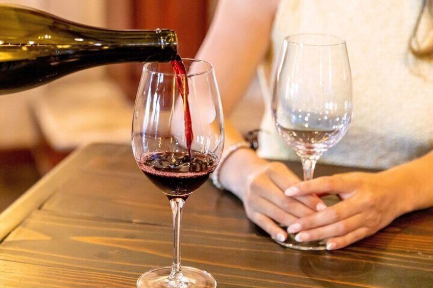 Pouring perfection—a glass of red wine to complement the intimate tasting experience.