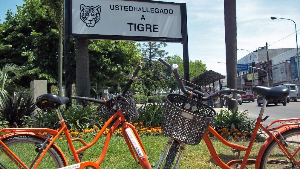 orange bicycle in front of Tigre sign 