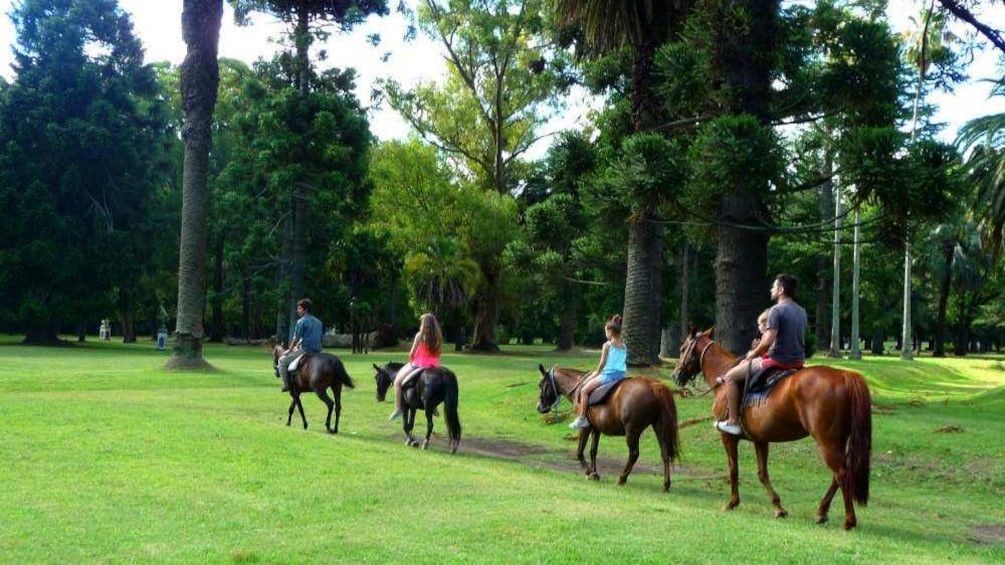 A group on horseback through the grounds of La Candelaria Ranch