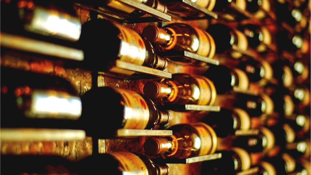 Close up of wine bottles on shelves.