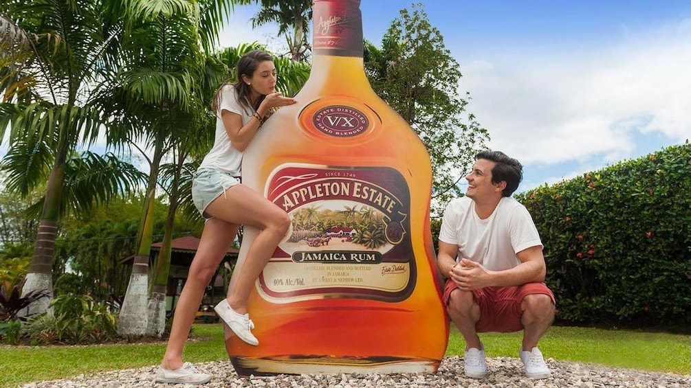 Couple posing with a cut out of a rum bottle at the Appleton Estate in Jamaica 
