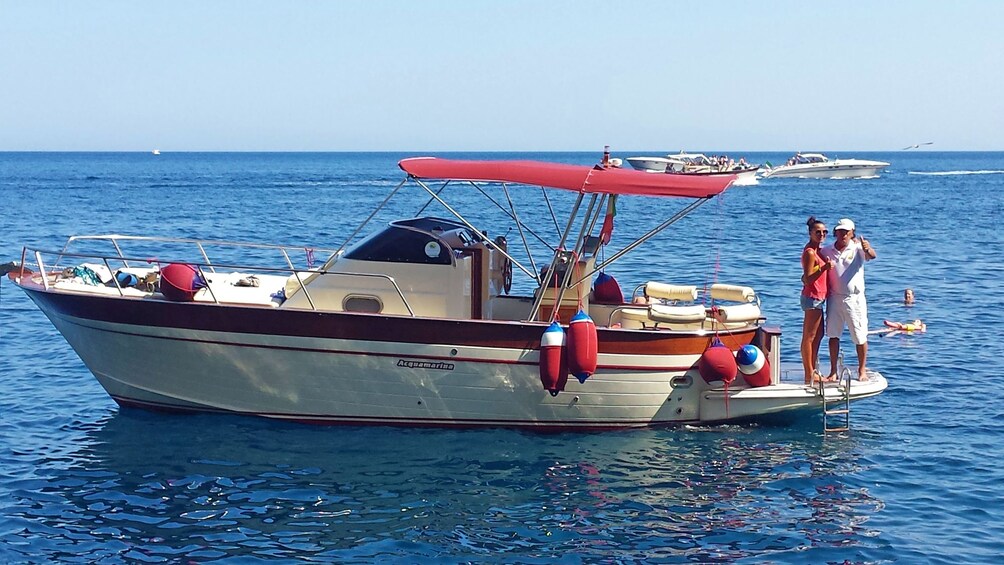 couple standing at the back of a boat in Italy